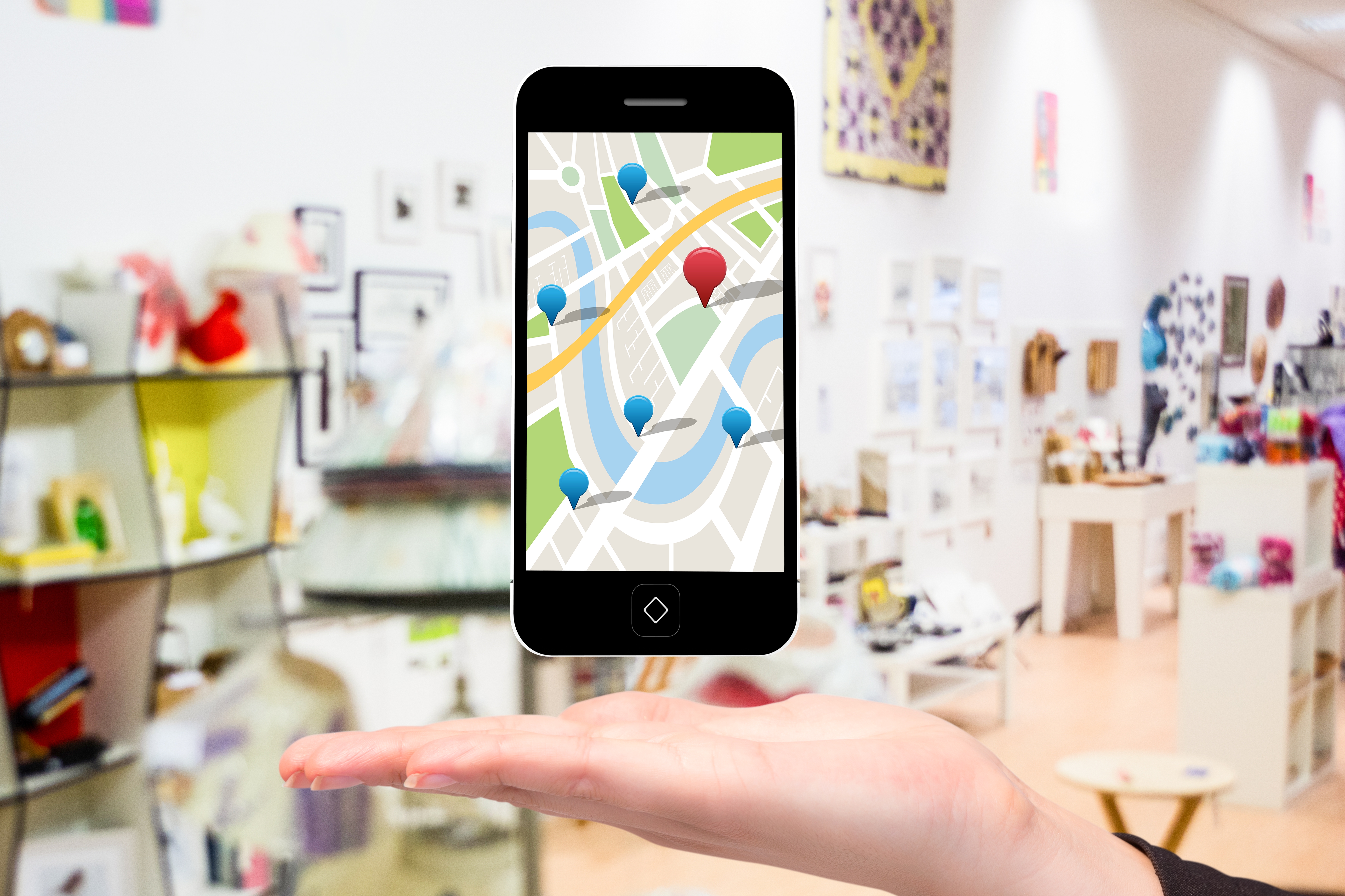 composite of hand holding smartphone with maps graphic with store background deo marketing local seo